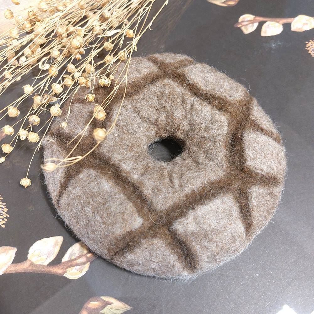 A felted wool trivet featuring the traditional Finnish rye bread.