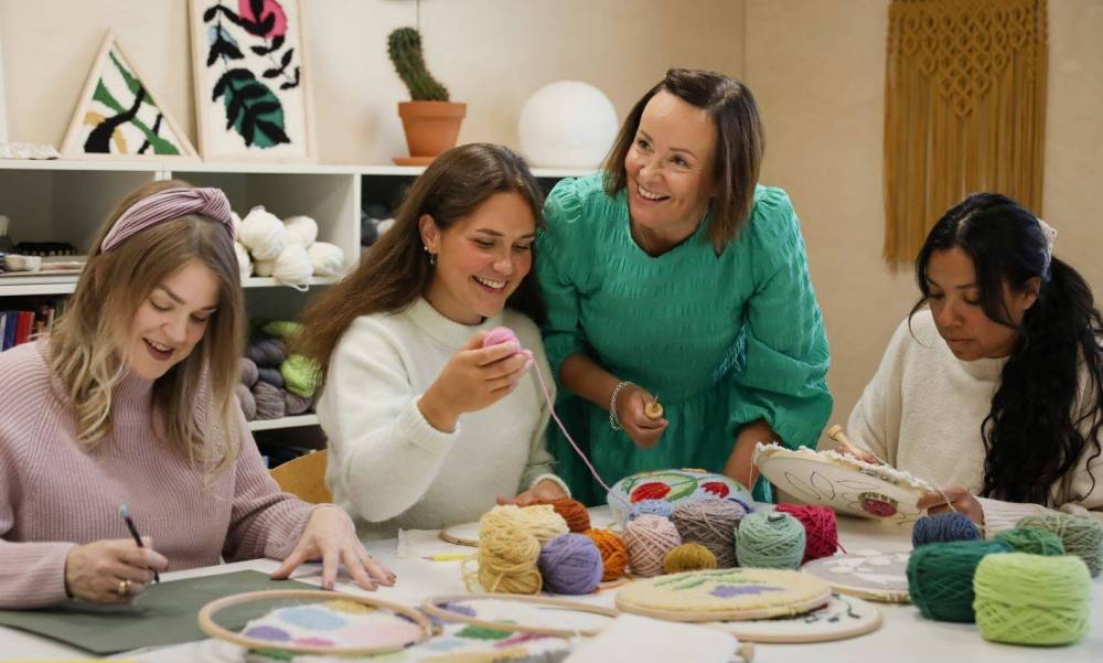A group of happy people learning punch needle skills