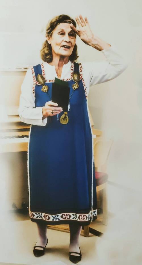 Rouva henkilö yllään karjalainen kansallispuku ja siihen kuuluvat asusteet