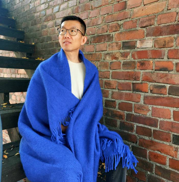 Klippanin sininen villaviltti kiedottuna nuoren miehen harteille