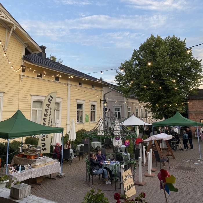 Taitokorttelin piha kesäiltana pihavalojen loisteessa